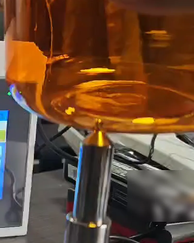 Shoulder and heel area of an amber plastic bottle on the probe tip